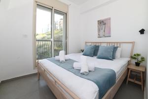 a large bed in a room with a large window at Yalarent Europe apartments- Luxury big apartmens with lake view in Tiberias