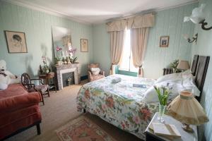 a bedroom with a bed and a chair and a fireplace at Château de la Tourlandry in Chemillé +134 photos
