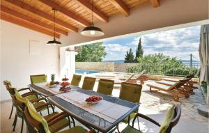 a dining room with a table and chairs on a patio at Stunning Home In Okrug Gornji With Heated Swimming Pool in Trogir