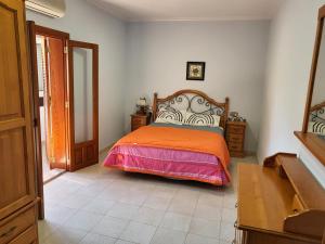 ein Schlafzimmer mit einem Bett mit einer orangefarbenen Decke in der Unterkunft rosa de los vientos in La Manga del Mar Menor