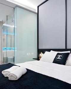una camera da letto con un grande letto con due asciugamani di Chanel Suite KL Tower View at Tropicana The Residence a Kuala Lumpur