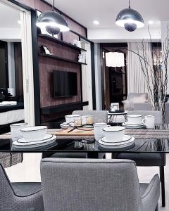 ein Esszimmer mit einem Tisch mit Tellern und Stühlen in der Unterkunft Chanel Suite KL Tower View at Tropicana The Residence in Kuala Lumpur