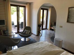 a bedroom with a bed and chairs and a living room at B&B Romy Rocker in Verona