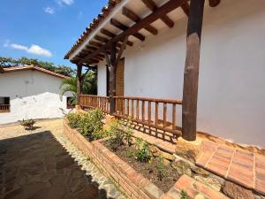 un porche de una casa con barandilla de madera en EcoHotel Barichara, en Barichara