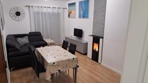 ein Wohnzimmer mit einem Sofa, einem Tisch und einem TV in der Unterkunft Appartement à Esmoriz de 3 pièces - 72m2 in Esmoriz