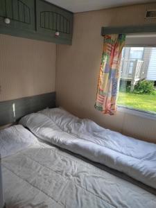 2 Betten in einem Zimmer mit Fenster in der Unterkunft Camping du Quinquis in Clohars-Carnoët