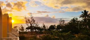 a sunset over the ocean from a balcony at Emplacement d'exception in Filaos