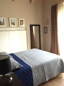 um quarto com uma cama com um cobertor azul e uma janela em Casa indipendente con giardino in città em Turim