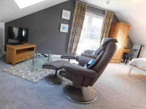 a living room with a chair and a television at Haven Lodge Newquay in Newquay