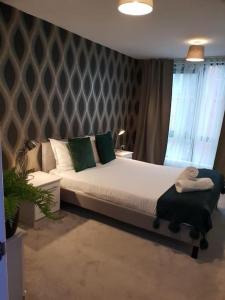 a bedroom with a large bed with green pillows at Luxury 9ine Beautiful Bull Ring Apartment Free Parking in Birmingham