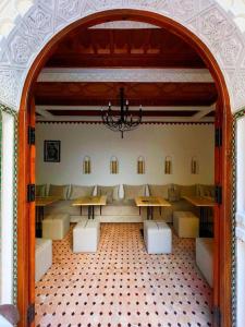 a room with tables and couches and a chandelier at RIAD KECHMARA in Marrakech