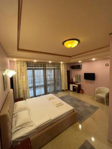 1 dormitorio con 1 cama grande y TV en Francesca Residence en Bucarest