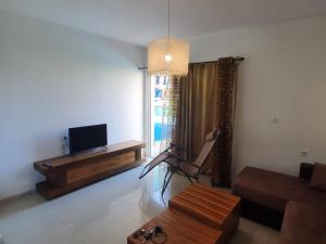 a living room with a couch and a tv at Beachfront Hotel: Pool, Spa, wet/dry Sauna & Gym in Ashqelon