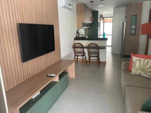 a living room with a flat screen tv on a wall at Itacimirim Beira Mar in Itacimirim