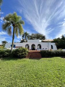 uma casa branca com uma palmeira em frente em Casa Mykonos Represa Avaré em Itaí