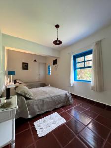 1 dormitorio con cama y ventana en Casa Mykonos Represa Avaré, en Itaí