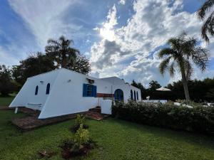 une église blanche avec des palmiers dans une cour dans l'établissement Casa Mykonos Represa Avaré, à Itaí