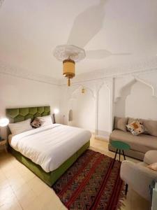 a bedroom with a large bed and a couch at RIAD KECHMARA in Marrakesh