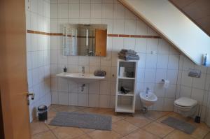 a bathroom with a sink and a toilet at Schnurs Ferienwohnung in Römerberg +19 photos