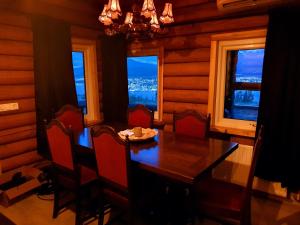 a dining room with a table and chairs and windows at Akureyri Loghouse in Akureyri