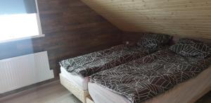 a bedroom with two beds and a wooden wall at Akureyri Loghouse in Akureyri