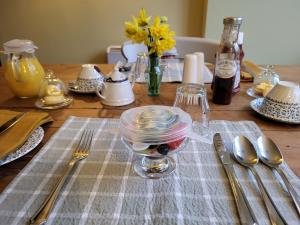 a wooden table with plates and utensils on it at The Green Door Vegan B&B in Llanon