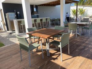 Itacimirim Beira Mar في إيتاسيميريم: طاولة وكراسي خشبية على الفناء