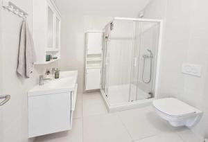 biała łazienka z prysznicem i toaletą w obiekcie Ferienhaus mit Meerblick & Pool in Baška - Villa-Planina w Bašce