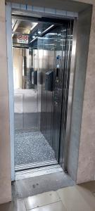 uma porta de vidro de um elevador num edifício em Studio near the sea em Batumi