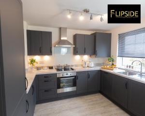 una cocina con armarios grises y fregadero en Contractors & Groups & Family Relocation - Flipside Property Aylesbury - Call Us Today For Special Offer!, en Bierton