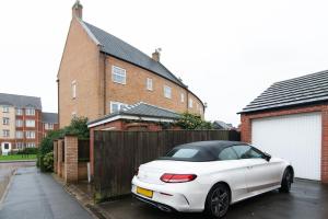 um carro branco estacionado em frente a uma casa em Pride Park House em Derby