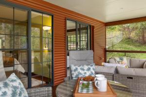 a screened in porch with a couch and a table at Stylish rural retreat on the foothills of Mt. Mee in Upper Caboolture