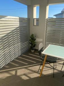 een tafel en stoel op een balkon met een hek bij Stylish 2Bed Close Airport/Shops in Perth