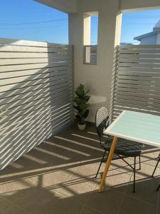 uma mesa e cadeira numa varanda com cerca em Stylish 2Bed Close Airport/Shops em Perth