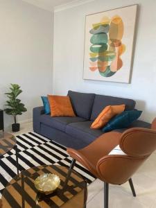 uma sala de estar com um sofá azul e uma mesa em Stylish 2Bed Close Airport/Shops em Perth