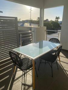 a glass table and chairs on a balcony at Stylish 2Bed Close Airport/Shops in Perth