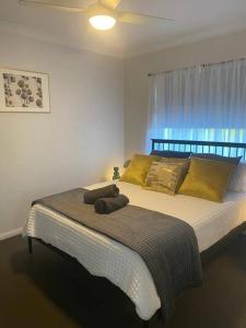 um quarto com uma cama grande e almofadas amarelas em Stylish 2Bed Close Airport/Shops em Perth