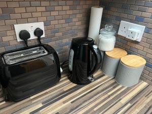 a toaster and coffee maker next to a brick wall at Entire Flat in Euston-Kings Cross in London