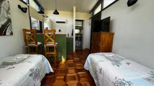 ビージャ・ラ・アンゴストゥーラにあるLa Claritaのベッド2台、テレビ、キッチンが備わる客室です。