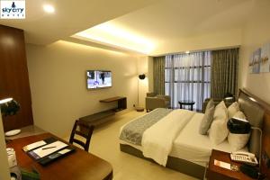 a hotel room with a bed and a desk at Sky City Hotel Dhaka in Dhaka