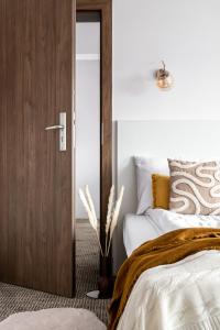 a bedroom with a wooden door leading to a bed at OBERŻA POD RÓŻĄ restauracja, sauny, jacuzzi in Nowy Targ