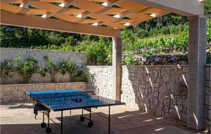 a ping pong table sitting under a pergola at Cozy Home In Dingac With Kitchen in Gornji Dingač