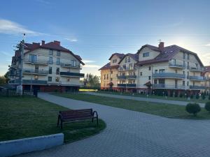 a park with a bench in front of some buildings at Apartamenty Baltyk in Karwia