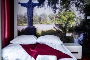 una cama con almohadas y una estatua de una cruz en Janowski Zakątek en Janów Lubelski