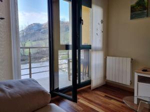 a living room with a large glass door to a balcony at 24A01 Apartamento Cabrales in Arenas de Cabrales