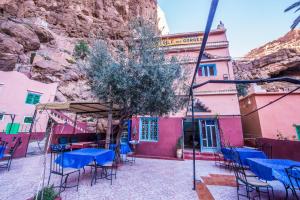 un grupo de mesas y sillas frente a un edificio en Etoile des Gorges en Aït Baha