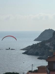 a person flying a parachute over the water at Casa del sasso in Bergeggi