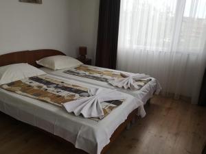 a bedroom with two beds with white sheets and a window at Rooms Zora in Primorsko