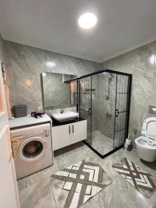 een badkamer met een wasmachine en een wastafel bij Merkezi Çift Teraslı Ev in Istanbul