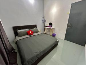 una camera da letto con un letto con un peluche rosso sopra di Home24#2pax#wifi&netflix#NearAeonAlma#heritage#NearAeonAlma#5KmtoIconCity#5kmtoSimpangAmpat a Bukit Mertajam